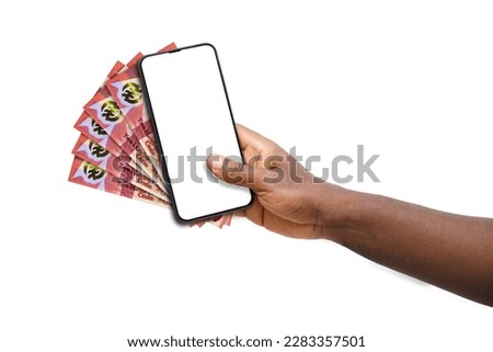 Black hand holding mobile phone with blank screen and Ghanaian cedi notes