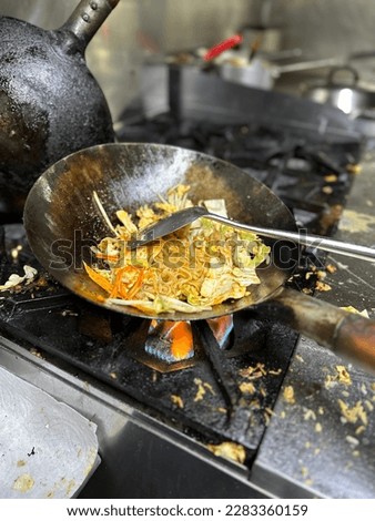 Cooking on fire wok for pad Thai and drunken noodle. Royalty-Free Stock Photo #2283360159