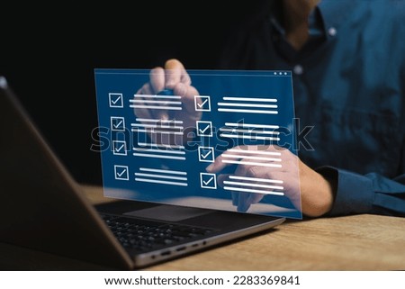 Digital smart checklist and business management on virtual screen concept, Businessman use laptop and use a pen marking on checklist paperless office and document management and future business  Royalty-Free Stock Photo #2283369841