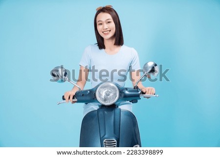 Young Asian woman on motorbike Royalty-Free Stock Photo #2283398899