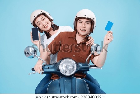 Young Asian couple ride scooter on background Royalty-Free Stock Photo #2283400291