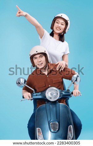 Young Asian couple ride scooter on background Royalty-Free Stock Photo #2283400305
