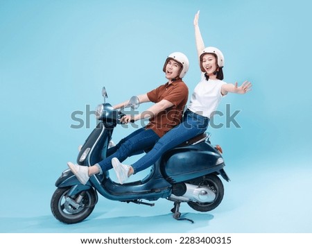 Young Asian couple ride scooter on background Royalty-Free Stock Photo #2283400315