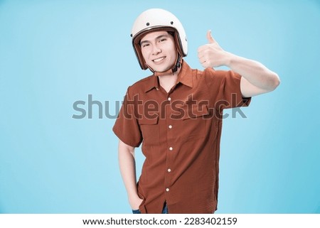 Young Asian man wearing helmet on background Royalty-Free Stock Photo #2283402159