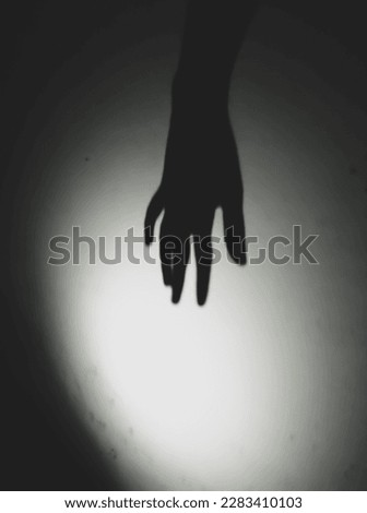Hand shadow on the wall. light, shadow with fuzzy edges against the background of the old wall. A photo with a frightening concept is a message from the hand of a ghost.