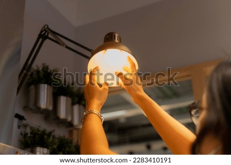 Hand woman changing with new LED lamp light bulb,Power saving concept. Reusing and recycling existing materials for future growth of business and environment sustainable.  Royalty-Free Stock Photo #2283410191