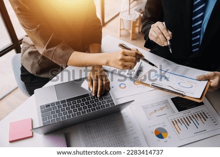 Financial analysts analyze business financial reports on a digital tablet planning investment project during a discussion at a meeting of corporate showing the results of their successful teamwork. Royalty-Free Stock Photo #2283414737