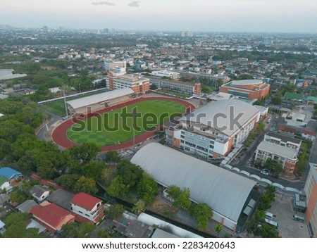 Aerial top view of soccer football sport recreation field ground, national stadium with university or college school campus buildings. Urban city town in Asia. Green court arena. Royalty-Free Stock Photo #2283420643