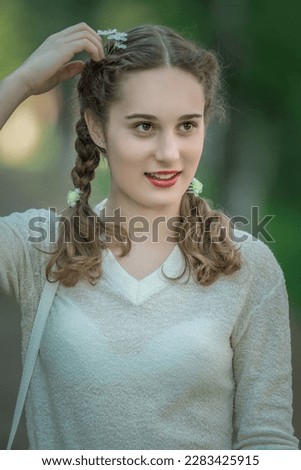 Portrait of a young beautiful fair-haired girl in a summer park.