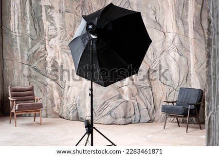 Photo studio interior with decorative wall, equipment and furniture elements.