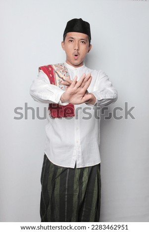 Concerned Indonesian Asian Man showing refusal sign, saying no, raise awarness not eating and drinking dyrung the day. standing on the white background.