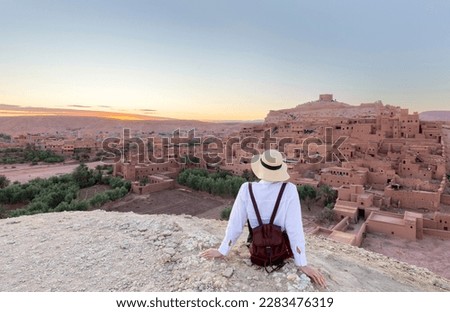 Ait Ben Haddou in the Atlas mountains of Morocco and woman tourist looking at the view Royalty-Free Stock Photo #2283476319