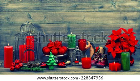 vintage christmas decorations with red candles, flower poinsettia, stars and baubles. dark designed retro style toned picture