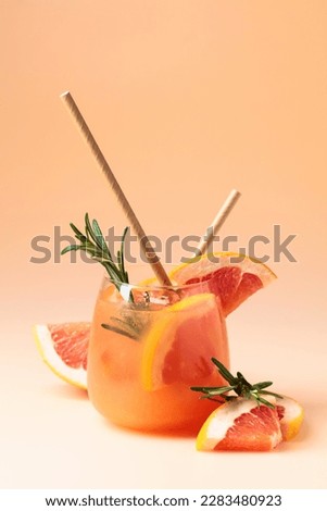 Summer cocktail with grapefruit, rosemary, and ice in a frozen glass.