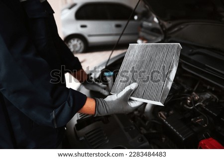 Car air conditioner system maintenance, Hand mechanic holding car air filter to check for clean dirty or fix repair heat have a problem or replace new or change filter. Royalty-Free Stock Photo #2283484483