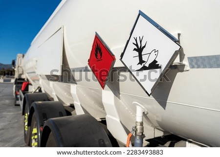 Flammable and environmental contaminant hazard labels on a tank truck with dangerous goods. Royalty-Free Stock Photo #2283493883