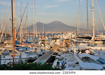 Yachts anchored in the marina of Naples at sunset with Mt.Vesuvius in the background