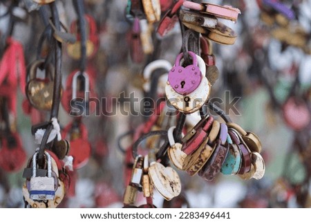 close up old rusty locks heart shaped on wire rope. Love lock on the bridge. tradition of hanging a barn lock on the wedding day