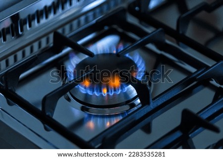 kitchen gas stove alight with flame coming out of it. Conceptual photo for gas, cost of bills, rising prices, heat and the environment. metal Ukraine, Russia, Europe. blu flame. united states. cook  Royalty-Free Stock Photo #2283535281