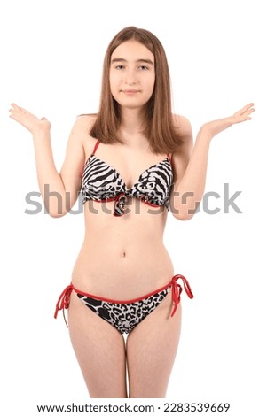 Young beautiful girl in a swimsuit on a white background, clueless and confused expression with arms and hands raised. Doubt concept.