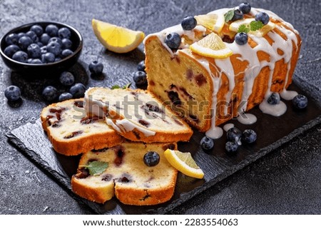 Lemon Blueberry Pound cake with Lemon Glaze on slate board on dark concrete table with fresh blueberries, close-up Royalty-Free Stock Photo #2283554063