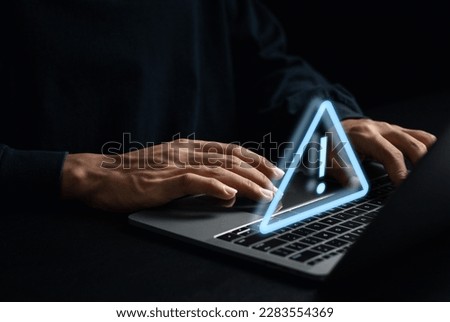 Developer using laptop with warning triangle sign for error notification and maintenance concept