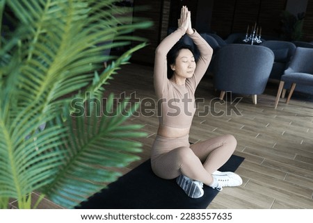 Sport woman doing yoga exercises on mat at home.