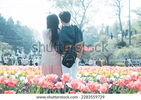A couple taking a picture in a tulip field