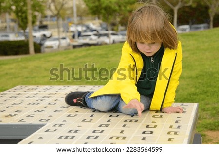 Little boy looks up the Hebrew alphabet. Learning with play. Hebrew letters. Learning Hebrew for kids. Royalty-Free Stock Photo #2283564599