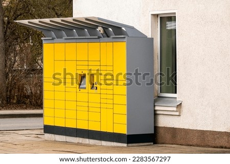 Yellow parcel pick up station on the street.Pick up locker box to receive parcels without contact and also send postage. Royalty-Free Stock Photo #2283567297