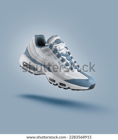 White sneaker with light blue accents on blue gradient background, sport concept, men's fashion, sport shoe, air, sneakers, lifestyle, concept, product photo, levitation concept, street  Royalty-Free Stock Photo #2283568915