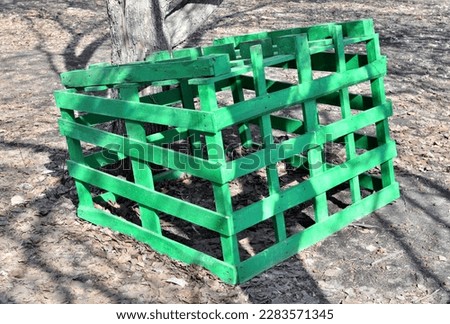 A wooden cage lies on the ground on a spring day
