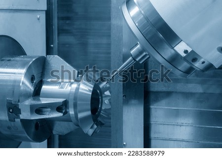 The 5-axis CNC milling machine  cutting the metal gear part. The hi-technology automotive part manufacturing process by CNC lathe. Royalty-Free Stock Photo #2283588979