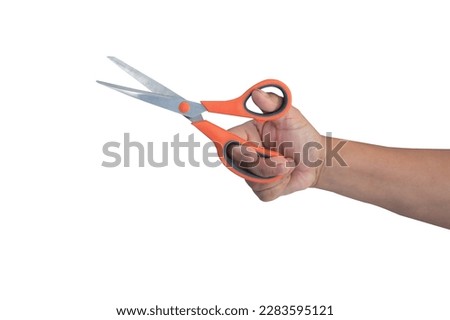 hand holding orange scissors isolated on white background