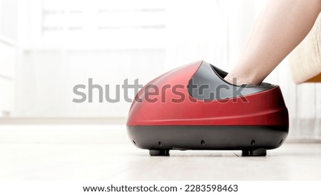 a girl does a foot massage on an electric foot massager. High quality photo