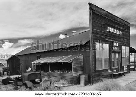 Gold Point in Nevada, USA. A ghost town with many abandoned houses, cars and no people. Background for horror movies. Famous spot in United States. Black and white photography.