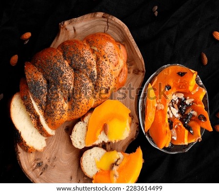Homemade bread, fresh bread beautifully sliced, on a black background, on a plate with pumpkin and poppy seeds