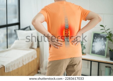 Lumbar intervertebral spine hernia, man with back pain at home, spinal disc disease, painful area highlighted in red Royalty-Free Stock Photo #2283617033