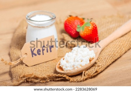 Kefir grains in wooden spoon in front of cups of Kefir Yogurt Parfaits. Kefir is one of the best health foods available providing powerful probiotics. Royalty-Free Stock Photo #2283628069