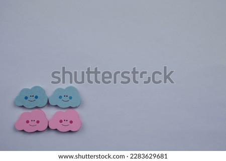 Colorful clouds placed on the edge of a white background, photographed from above, colorful clouds.  pink, green, happy, emoji