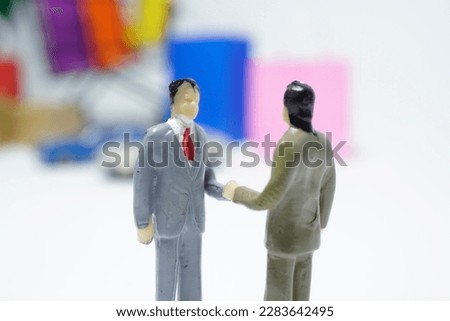 two small mockup men shaking hands to make a business deal business concept and white background
