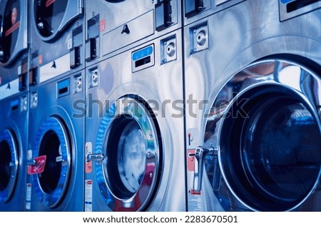 Rows of industrial laundry machines in the large laundromat. Royalty-Free Stock Photo #2283670501