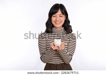 Portrait of young Asian woman holding white piggy bank isolated on white background, Financial and bank saving money concept