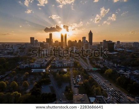 aerial drone footage of Atlanta downtown skyscraper  during sunsets. the bright orange sun goes down between the building architectures related to urban travel, vacations and traffic 