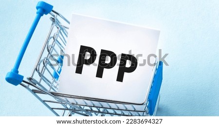 Shopping cart and text ppp loan on white paper note list. Shopping list concept on blue background.