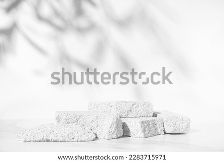 Beauty skin care product presentation podium and display with copy space made with porous stones on white sunny background. Studio photography.