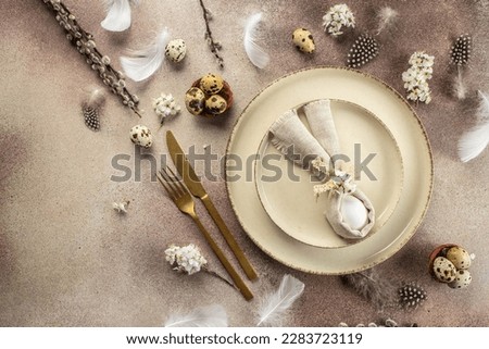 Table setting for celebrating easter. Easter egg in bunny napkin on plate. Happy Easter holiday concept. place for text, top view.