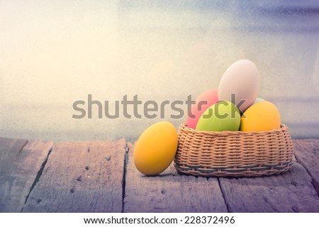 Easter eggs in the nest on rustic wooden background Royalty-Free Stock Photo #228372496
