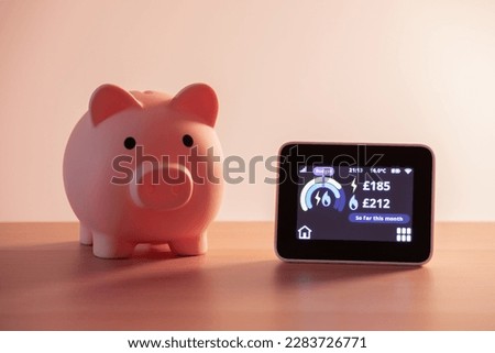 Smart meter, energy meter. Checking domestic electricity and gas use. Smart meter reading over budget. Piggy bank, savings. Royalty-Free Stock Photo #2283726771
