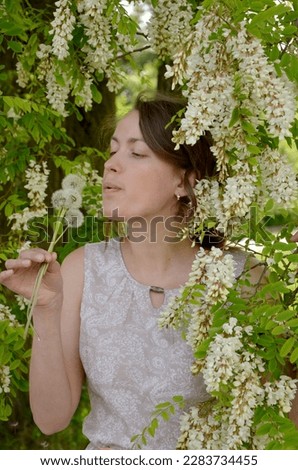 portrait of a young woman near a flowering acacia